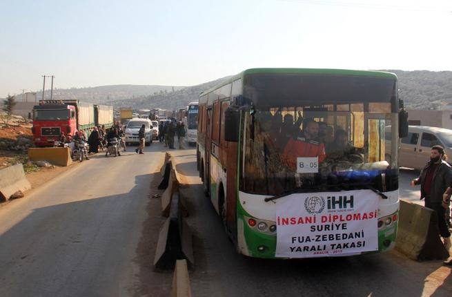 A convoy of transporting wounded Syrian civilians and rebels from the villages of Fuaa and Kafraya heads towards the Cilvegozu crossing with Turkey