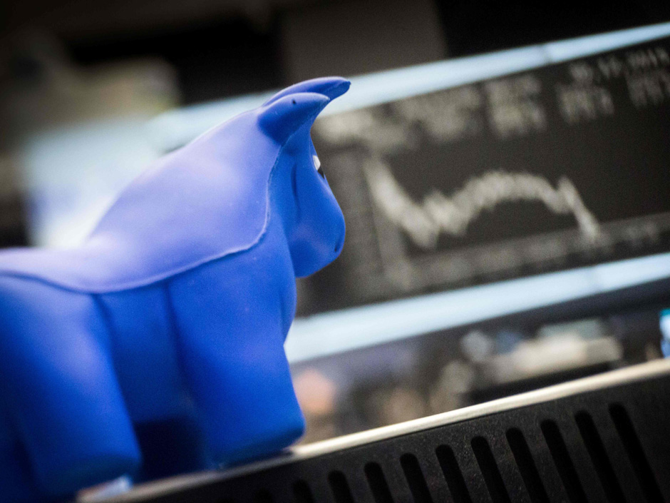 A toy bull is seen in front of a board displaying Germany's share index DAX at the stock exchange in Frankfurt am Main western Germany