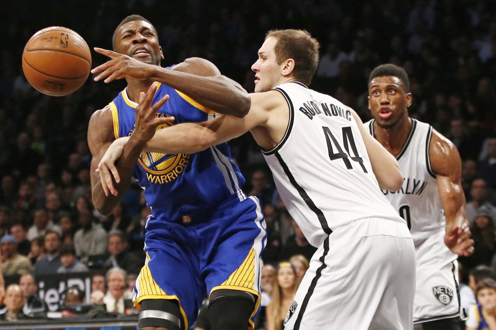 Nets guard Bojan Bogdanovic right fouls Warriors center Festus Ezeli in the first half Sunday in New York. The Warriors won their 26th straight regular-season game