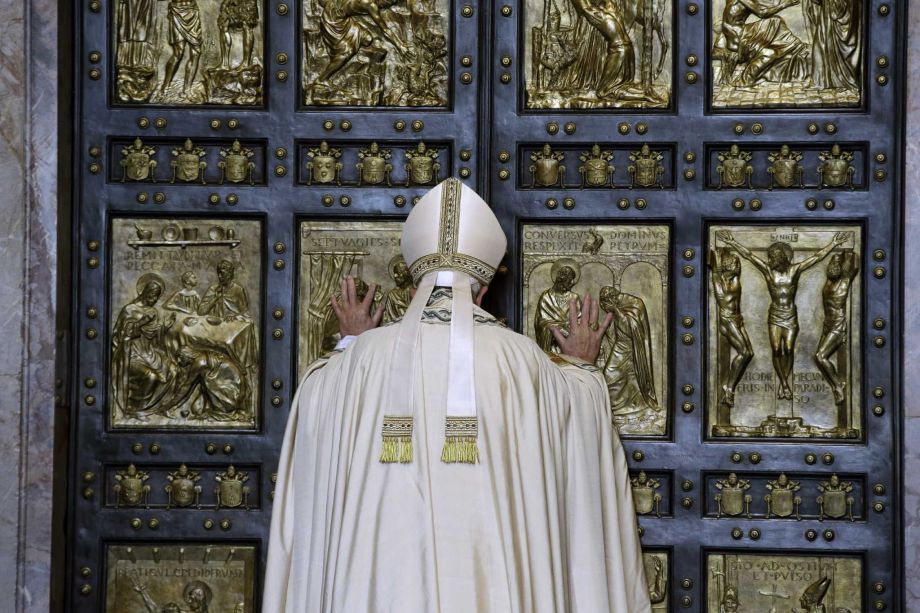 Pope Francis pushes open the Holy Door of St. Peter's Basilica formally launching the Holy Year of Mercy at the Vatican Tuesday Dec. 8 2015. The 12-month jubilee emphasizes what has become the leitmotif of his papacy to show the merciful and welcomi