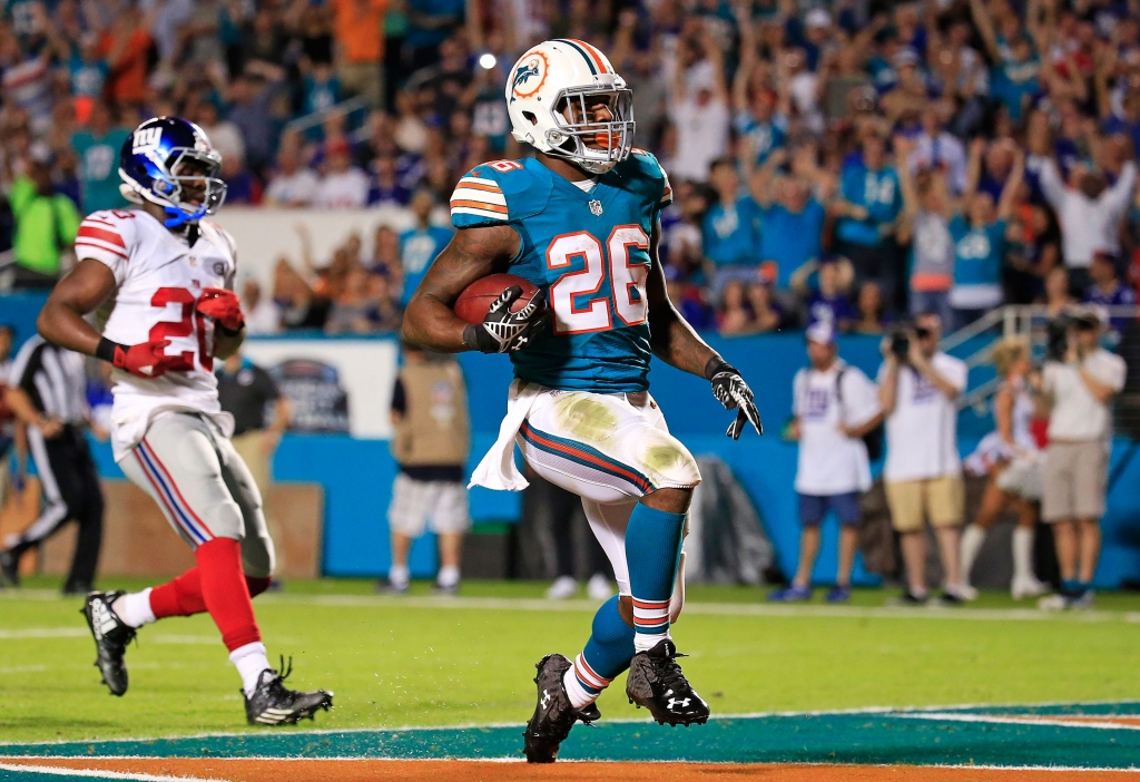 Lamar Miller #26 of the Miami Dolphins runs for a touchdown during the first half of the game against the New York Giants at Sun Life Stadium