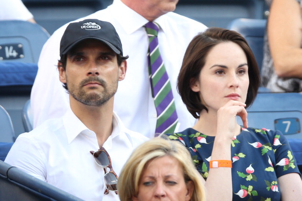 NEW YORK NY- SEPTEMBER 06 John Dineen and Michelle Dockery watch the women's singles semifinal match between Serena Williams of United States of America and Na Li of China on Day Twelve of the 2013 US Open at USTA Billie Jean King National Tennis