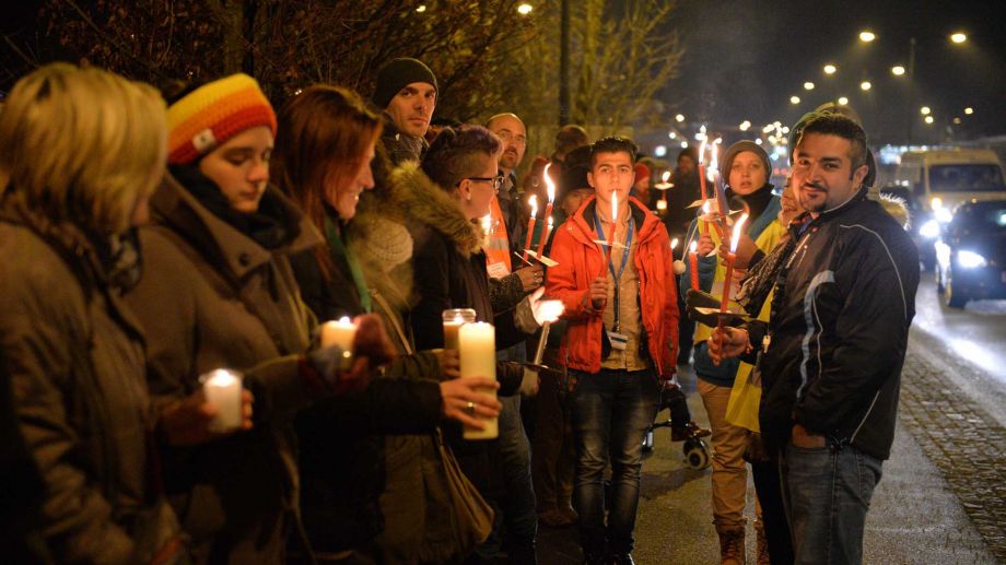 Participants with candles and torches stand on a bridge at the border between Austria and Germany during a demonstration for'Human refugee policy in a Europe without borders in support of migrants in Salzburg Austria Monday Dec. 14 2015