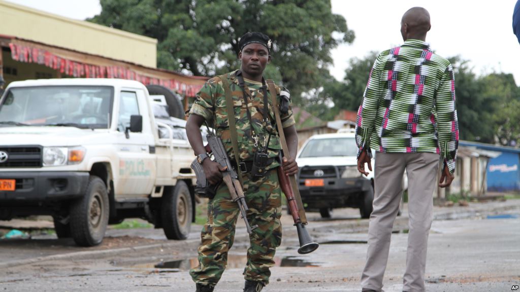 FILE- A Burundian soldier with his gun and rocket launcher guard a deserted street in Bujumbura Burundi