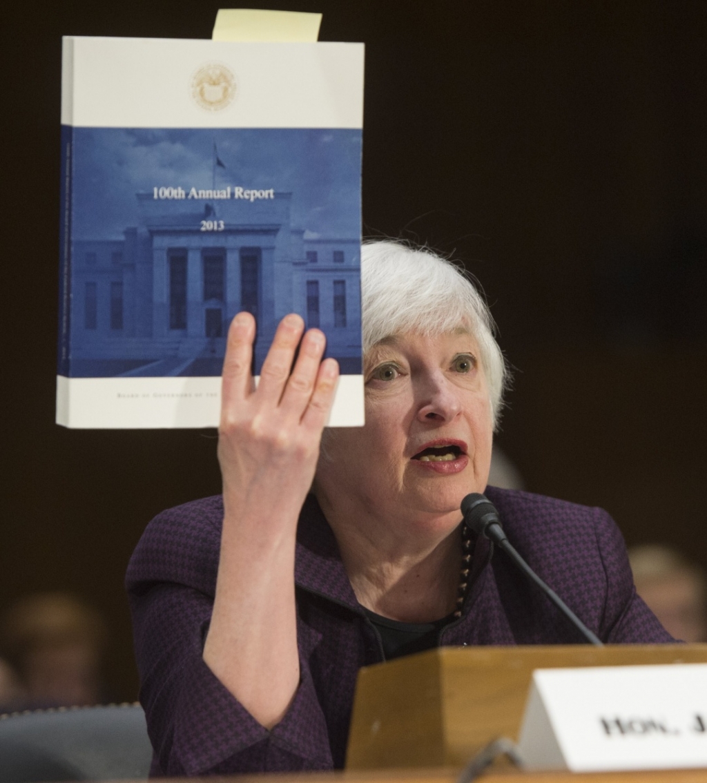 Federal Reserve Board Chairwoman Janet Yellen holds up a copy of the Federal Reserve’s 100th Annual Report