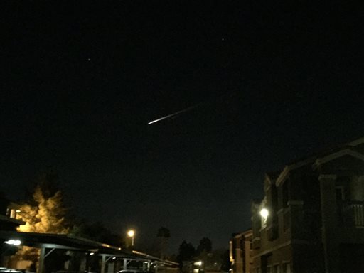 A streak of light is seen over an apartment complex in Las Vegas on Tuesday Dec. 22 2015. U.S. Military officials say the streak of light seen burning across the sky by people in three Western states was debris from a Russian rocket re-entering the atmo