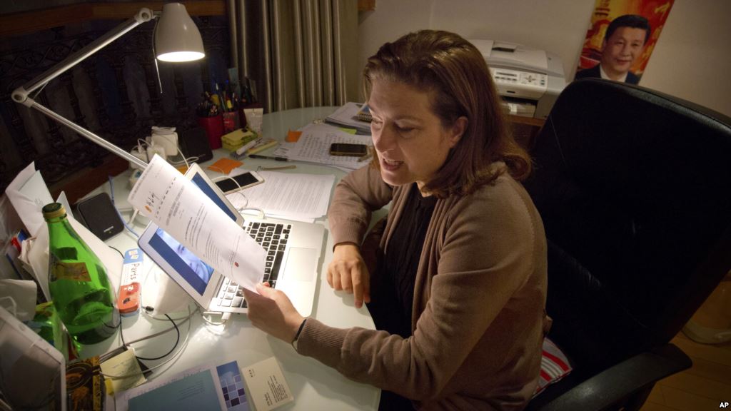 French journalist Ursula Gauthier a reporter for the French news magazine L'Obs holds a statement criticizing her from the Chinese Ministry of Foreign Affairs as she sits at her desk in her apartment in Beijing Dec. 26 2015