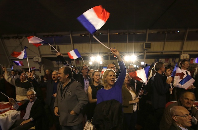 Supporters of far right National Front party regional leader for southeastern France Marion Marechal Le Pen wave flags at a meeting after the results of the first round of the regional elections in Carpentras southern France Sunday Dec. 6 2015. Fre