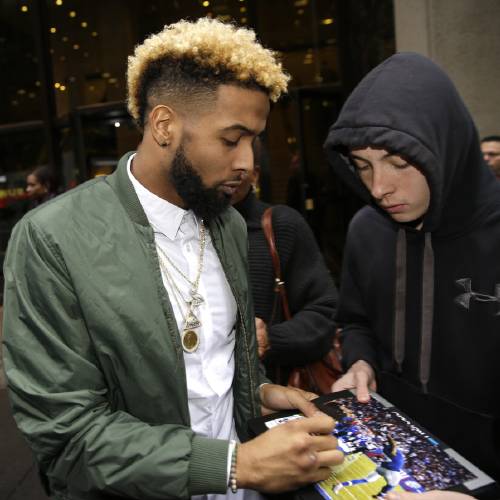 GiantsÂ’ Odell Beckham Jr. signs an autograph as he leaves NFL headquarters in New York Wednesday Dec. 23 2015. Hearing officer James Thrash upheld the suspension for multiple violations of safety-related playing rules after hearing