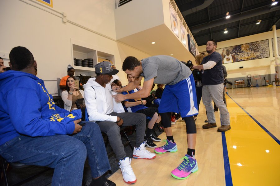 Golden State Warriors guard Stephen Curry autographs a sweatshirt worn by Stephen Cunderland 19 of Port St. Lucie