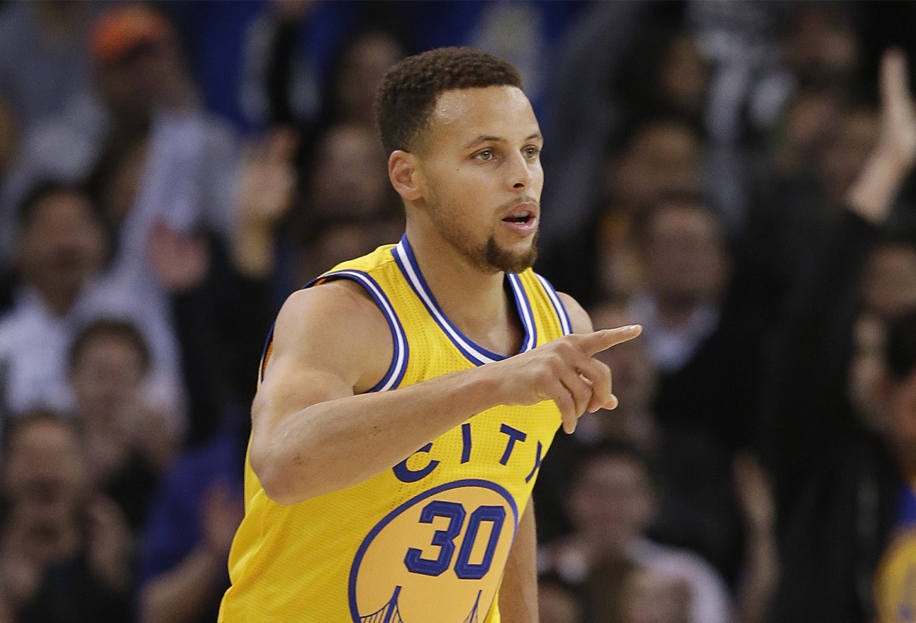 Golden State Warriors guard Stephen Curry reacts after making a 3-point basket during the first half of an NBA basketball game against the Los Angeles Lakers in Oakland on Tuesday