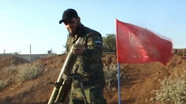 A Turkmen fighter loads a mortar while fighting Syrian government forces