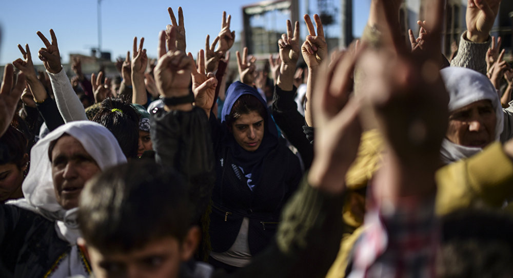 Members of the Kurdish community flash the V for victiry sign during a demonstration in Sirnak