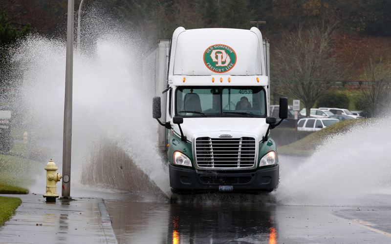 PORTLAND TRIBUNE JONATHAN HOUSE- A truck plowed through a flooded street in Milwaukie on Monday just one of many in the area that were swamped and even closed by record rainfall