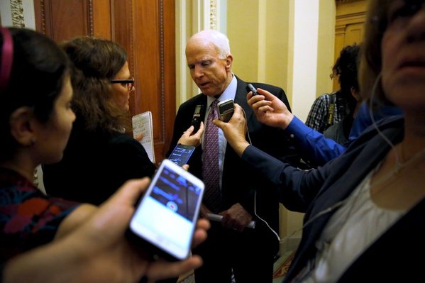 U.S. Senator John Mc Cain  speaks with a reporter after the weekly Republican caucus luncheon at the U.S. Capitol in Washington