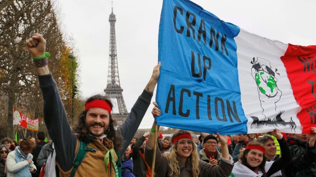 Environmentalists hold a banner which reads'Crank up the Action at a protest demonstration near the Eiffel Tower in Paris France