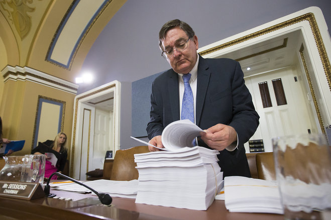 House Rules Committee member Rep. Michael C. Burgess R-Texas examines a printout of the $1.1 trillion spending bill to fund the government for the 2016 budget year and extend $680 billion in tax cuts for businesses and individuals at the Capitol in Was