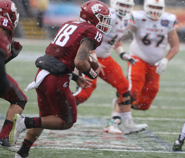 ASSOCIATED PRESS           Washington States Shalom Lunai carries the ball after intercepting a pass during the second half of the Sun Bowl NCAA college football game against Miami today in El Paso Texas