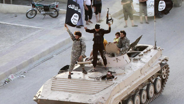 ISIS fighters take part in a parade in Syria's northern Raqqa province