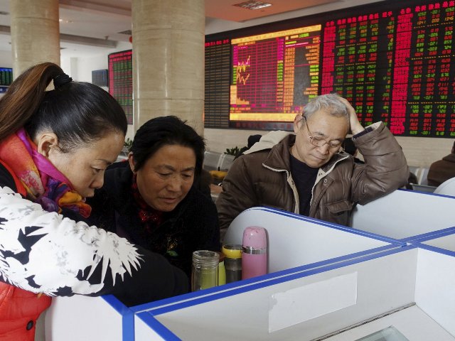 Investors look at computer screens showing stock information at a brokerage house in Fuyang Anhui province,China. File