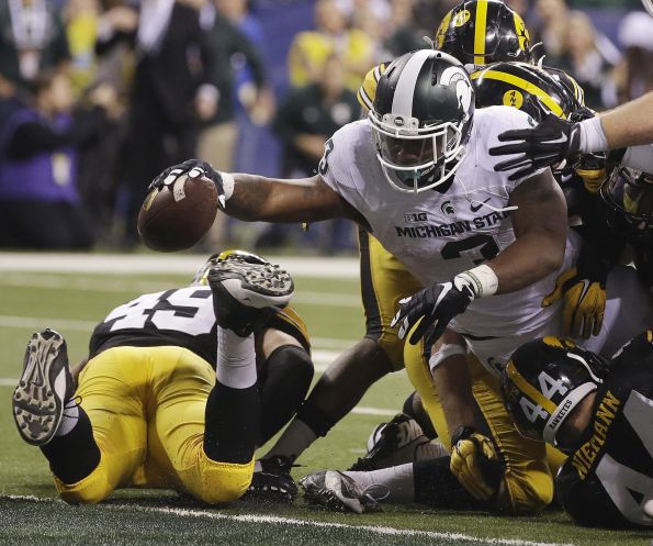 Michigan State running back LJ Scott reaches the ball over the goal line for the winning 1-yard touchdown run in the final minute against Iowa