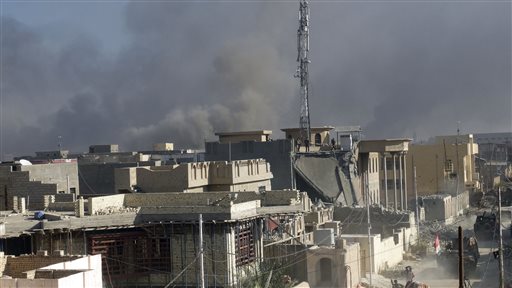 Smoke rises as Iraqi security forces attack the government complex in central Ramadi 70 miles west of Baghdad Iraq Monday Dec. 28 2015. Iraqi military forces on Monday retook a strategic government complex in the city of Ramadi from