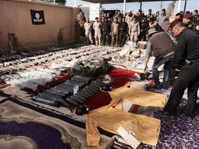 Iraqi security forces look at confiscated Islamic State group weapons and ammunition after regaining control over the last week in Ramadi Iraq's Anbar prov