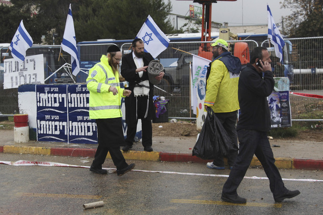 Israeli emergency service members stand at the scene of an alleged stabbing attack at Gush Etzion junction in the West Bank on Tuesday Dec. 1 2015. A Pales