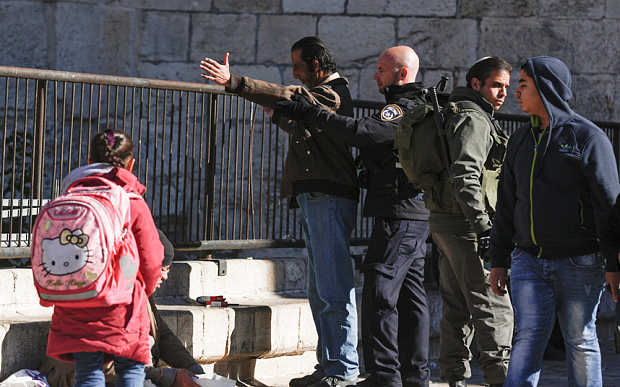 Israeli police search a Palestinian man at the Damascus Gate in the Old City of Jerusalem