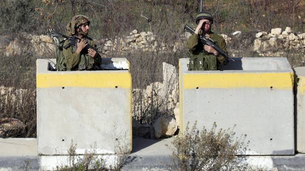 Israeli soldiers stand guard at Halhul checkpoint near Hebron