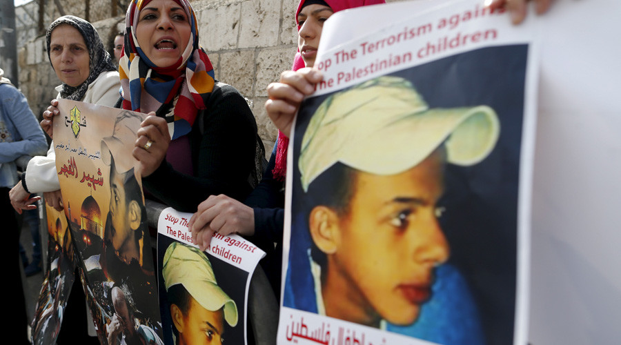 Palestinians protest outside the Jerusalem District Court during the trial of suspects accused of murdering Palestinian teenager Mohammed Abu Khudair