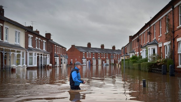 A local resident wades through flood waters in Carlisle England