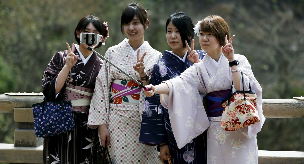 Kimono-clad women take selfies by using a selfie stick at Kiyomizu-dera Buddhist temple in Kyoto western Japan