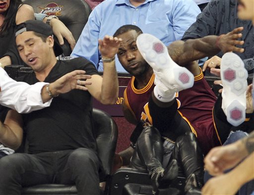 Cleveland Cavaliers Le Bron James falls into Ellie Day wife of PGA Tour golf player Jason Day at left during the second half of an NBA basketball game against the Oklahoma City Thunder Thursday Dec. 17 2015 in Cleveland. (John Kuntz  The Plain Deale