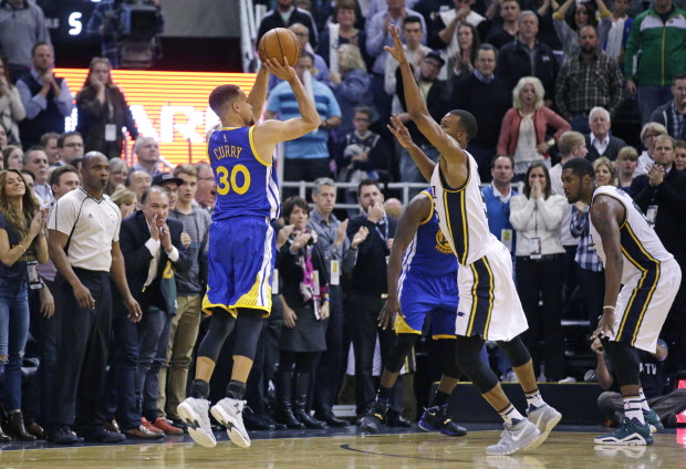 Golden State Warriors guard Stephen Curry hits a 3-pointer against Utah Jazz guard Rodney Hood in the second half during an NBA basketball game Monday night in Salt Lake City. The Warriors won 106-103