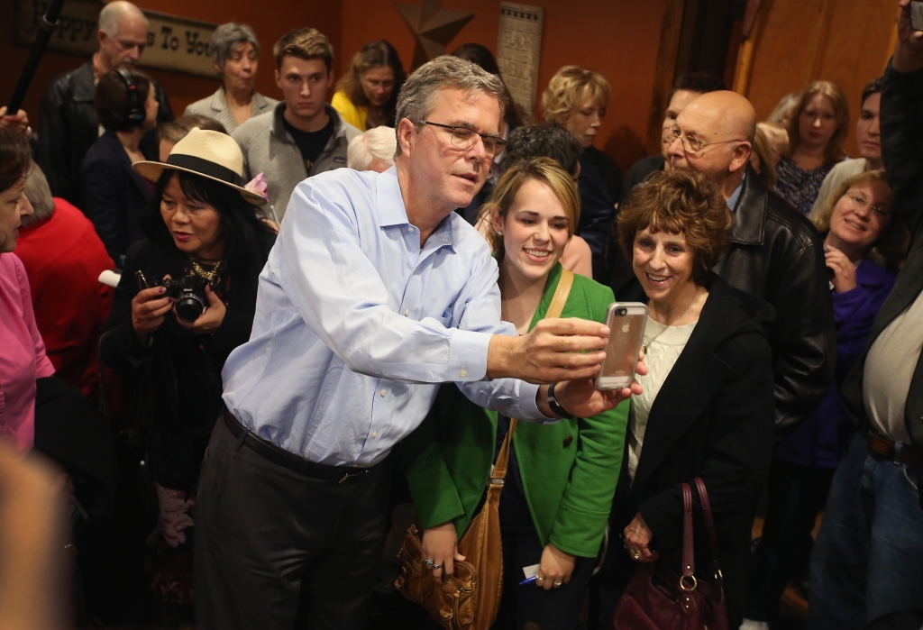 Former Florida Gov. Jeb Bush takes a selfie with an Iowa resident after speaking at a Pizza Ranch restaurant