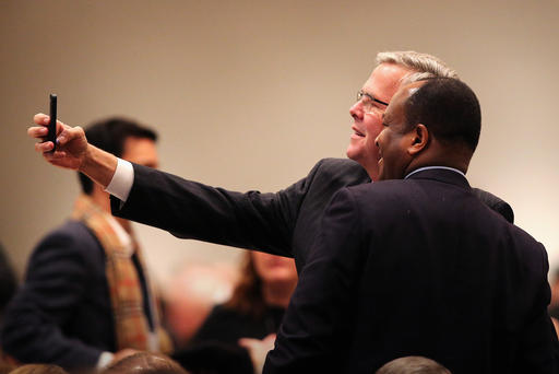 Former Florida Governor Jeb Bush takes a selfie with a guest at a luncheon on Feb. 18 2015 in Chicago Ill