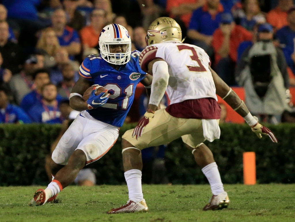 Kelvin Taylor #21 of the Florida Gators attempts to run past Derwin James #3 of the Florida State Seminoles during the game at Ben Hill Griffin Stadium