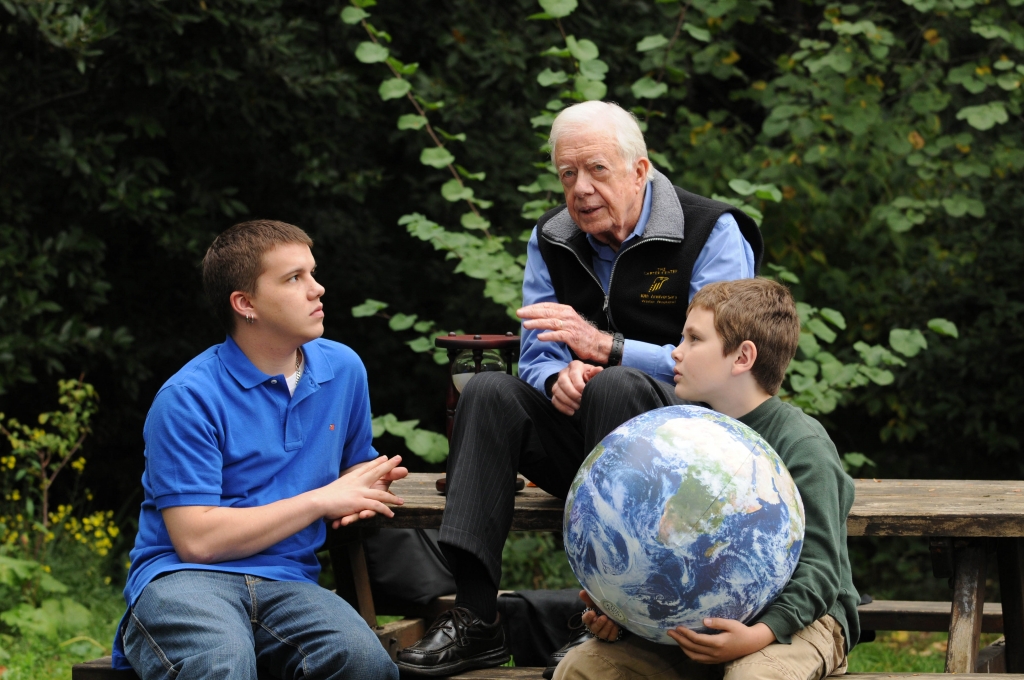 In this handout image provided by the Elders Jimmy Carter walks with his grandsons Jeremy Carter, 22 and Hugo Wentzel 10 during a picnic event