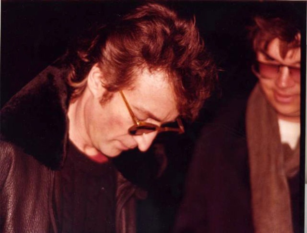 John Lennon with Mark Chapman outside the Dakota building December 8 1980. John is signing his autograph on an album cover for Chapman who would murder the former Beatle later that same day