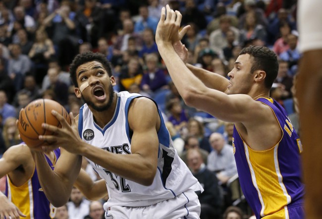 Minnesota Timberwolves center Karl Anthony Towns drives against Los Angeles Lakers forward Larry Nance Jr. right during the first half of an NBA basketball game in Minneapolis Wednesday Dec. 9 2015