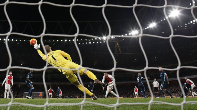 Arsenal midfielder Theo Walcott watches his shot beat Manchester City goalkeeper Joe Hart as he scores his team's first goal during the English Premier League football match between Arsenal and Manchester City. AFP