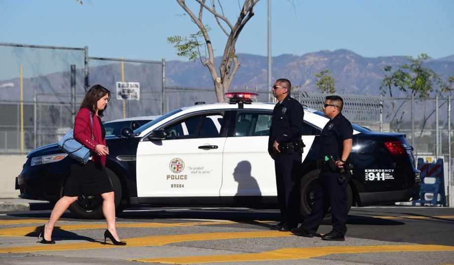 Policemen patrol a school near downtown Los Angeles after the district shut down all public schools. Officials later said that what was at the time thought to be a credible emailed threat was probably a hoax