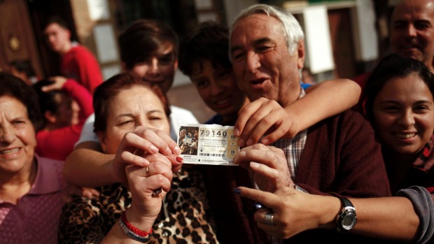 Winners hold a lottery ticket showing the first prize winning number 79140 of Spain's Christmas Lottery'El Gordo  as they celebrate in Villanueva de la Concepcion near Malaga Spain