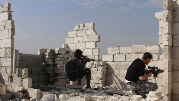 Free Syrian Army fighters sit in shooting position in Aleppo's Karm al Jabal district