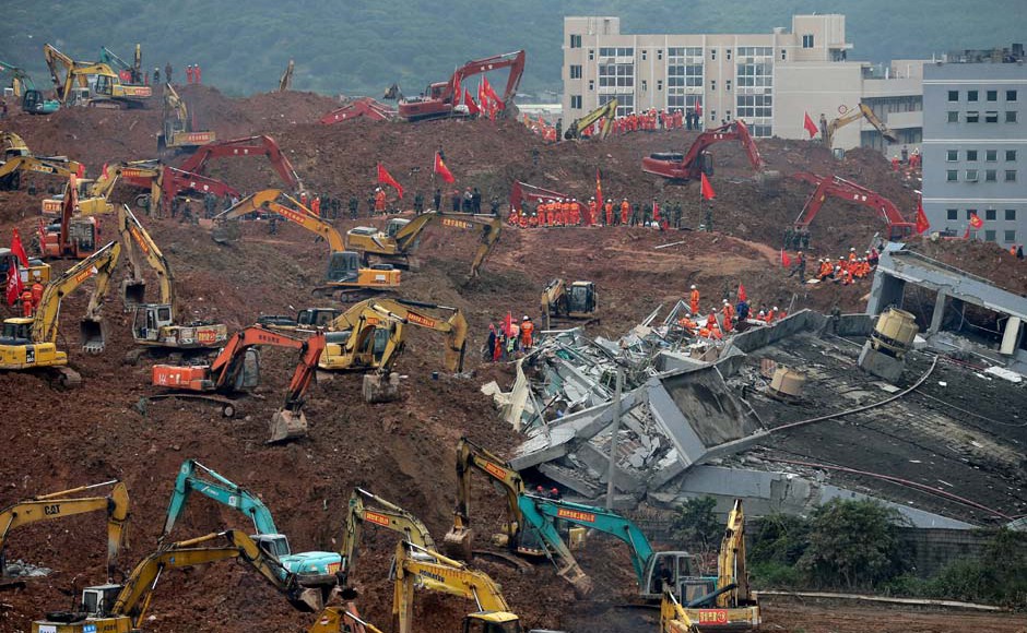 Rescuers using excavators dig the sea of soil to search for potential survivors near the damaged building following a landslide at a industrial park in Shenzhen in south China's Guangdong province Tuesday Dec. 22 2015. Pic AP