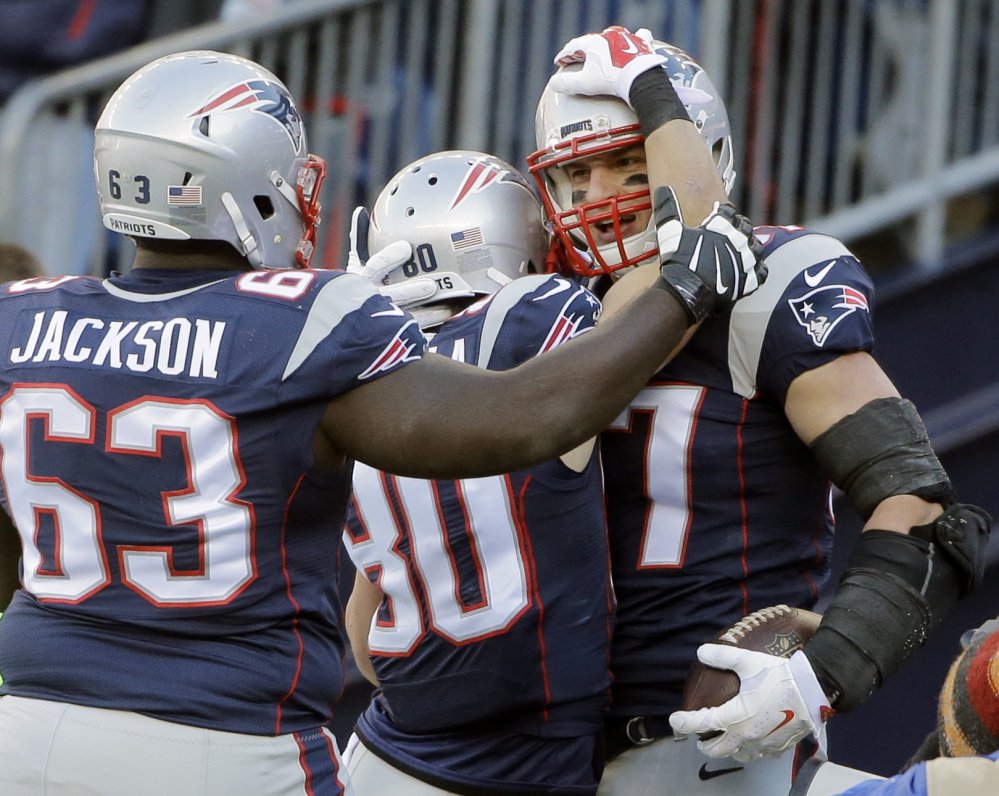 Patriots tight end Rob Gronkowski right celebrates his touchdown catch with guard Tre’ Jackson 63 and wide receiver Danny Amendola in the first half Sunday against the Tennessee Titans in Foxborough Massachusetts