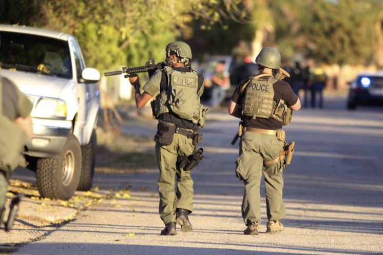 Police at the scene of a shootout about a mile from the site where gunmen left at least 14 dead at a conference hall where county employees had gathered in San Bernardino Calif