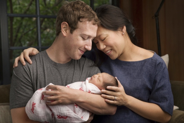 Max Chan Zuckerberg is held by her parents Mark Zuckerberg and Priscilla Chan Zuckerberg