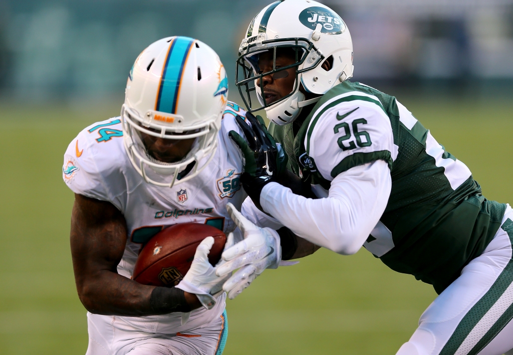 Jarvis Landry #14 of the Miami Dolphins scores a touchdown as Darrin Walls #26 of the New York Jets defends